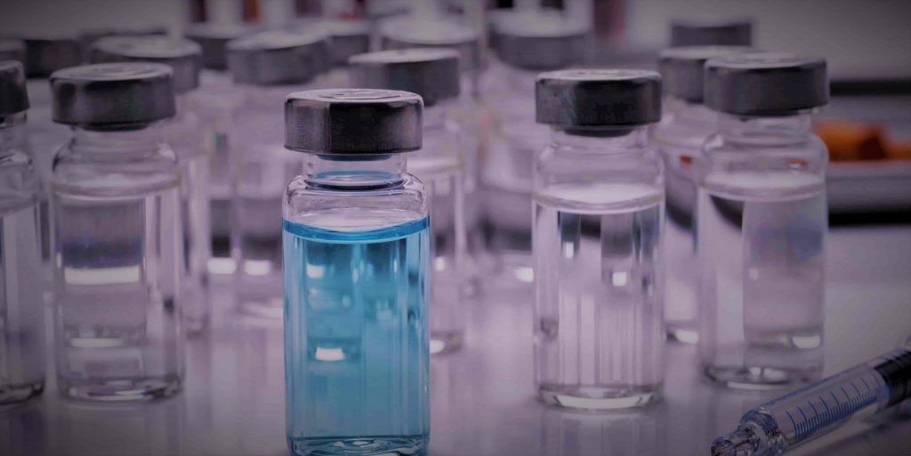 Rows of glass vials holding liquid medicine.